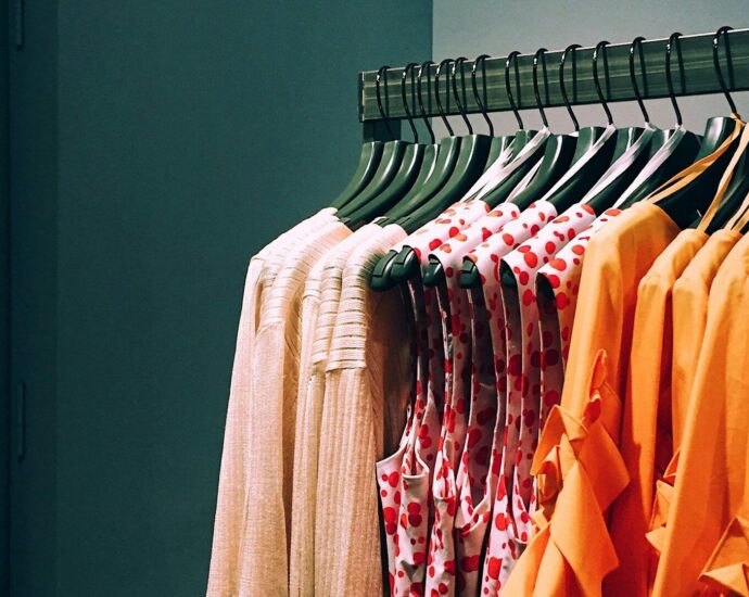 Orange and pink shirts hung on a clothing rail